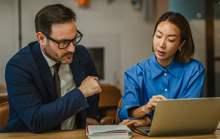 colleagues reviewing work together on laptop