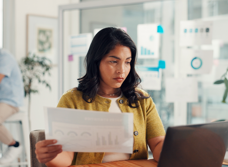 person reviewing report and analysing data on laptop